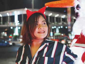 Portrait of smiling young woman at night