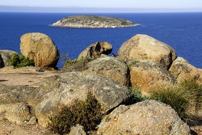 Rocks by sea against sky