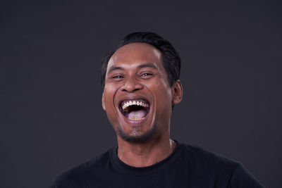 Portrait of young man against black background