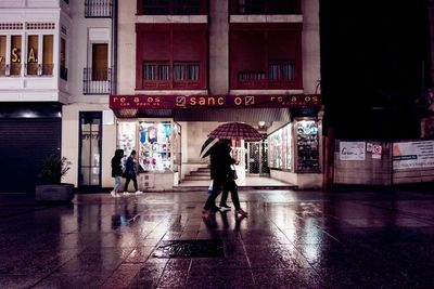 People walking on wet street in rainy season