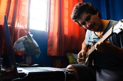 Young man working on table at home