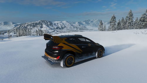 Car on snow covered mountain against sky