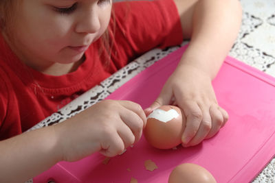 Low angle view of girl playing with tattoo on table