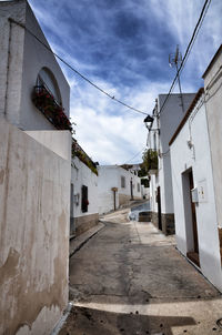 Street amidst buildings in town against sky