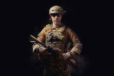 Portrait of mature man in military uniform against black background