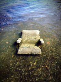 Deck chair by sea against sky