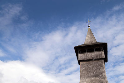 Low angle view of cross on building against sky