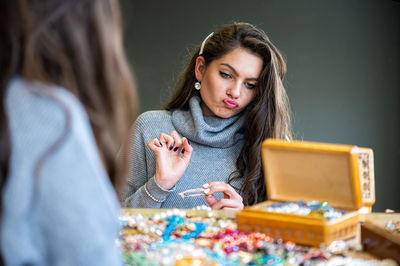 Young woman using phone while sitting on table