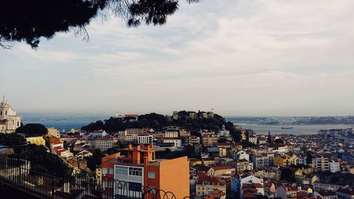 Cityscape by sea against sky