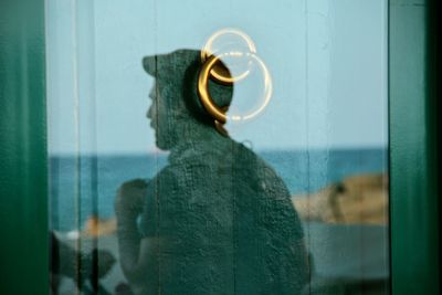 Rear view of man standing against window