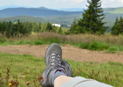 Low section of person relaxing on field