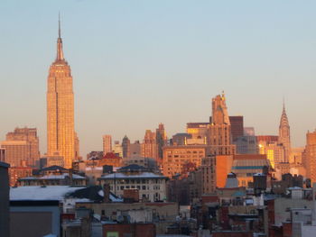 Buildings in city against clear sky