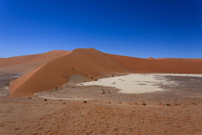 Scenic view of desert against clear blue sky