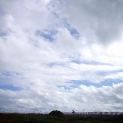 Scenic view of field against cloudy sky