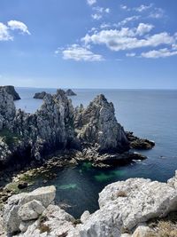 Scenic view of rocks in sea against sky