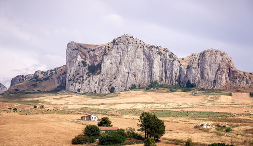 Fields in a landscape of a rocky formation.