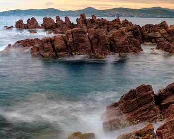 Scenic view of rocks in sea against sky