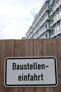 Information sign on built structure against the sky