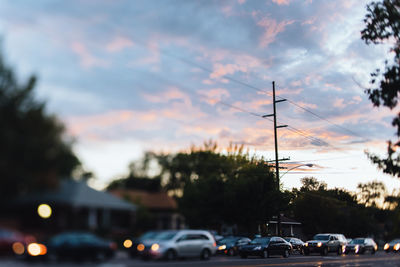 Cars on road against sky during sunset