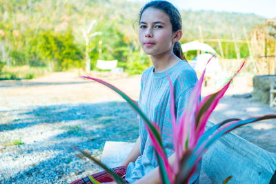 Portrait of young woman sitting on field