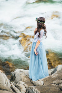 Woman standing on rock at shore