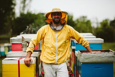 Beekeeper working over beehive at farm