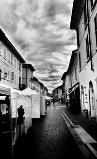Buildings in city against cloudy sky