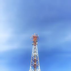 Low angle view of communications tower against blue sky