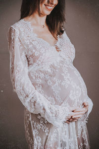 Midsection of woman standing against wall