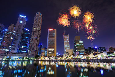 Firework display over illuminated buildings in city at night