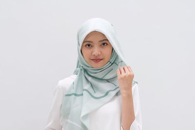 Portrait of smiling girl standing against white background