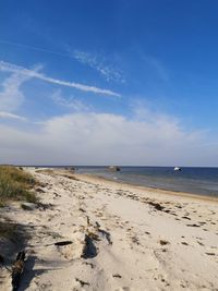 Scenic view of beach against blue sky