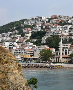 Buildings by sea against sky in city