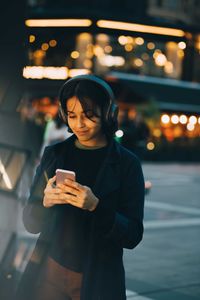 Man using mobile phone while standing in city