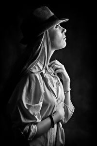 Young woman standing against black background