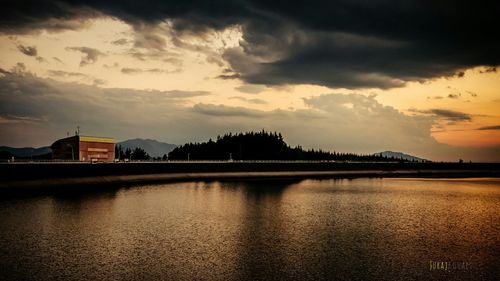 Buildings against cloudy sky at sunset