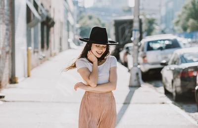 Full length of woman wearing hat standing in city