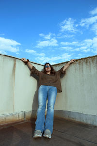 Portrait of woman standing against wall