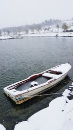 Boat moored in lake against sky