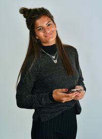 Portrait of smiling girl standing against white background