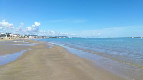 Scenic view of beach against blue sky