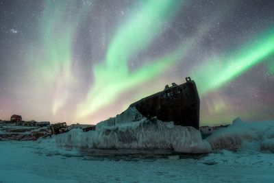 Scenic view of frozen lake against sky at night