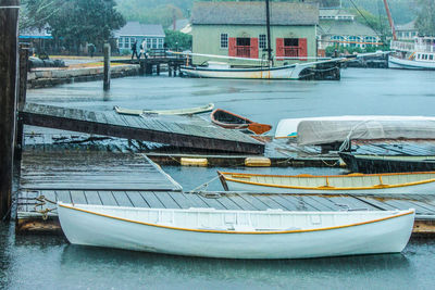 Sailboats moored on river by buildings in city