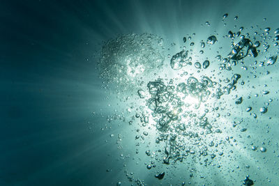 Close-up of wet glass against blue background