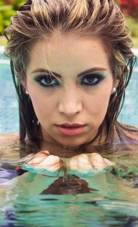 Close up portrait of beautiful woman swimming in pool