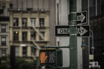 Close-up of road sign against buildings in city