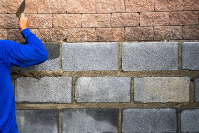 Man holding stone wall