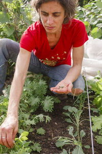 Midsection of woman looking at plants