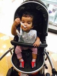 Portrait of smiling baby boy sitting in baby stroller