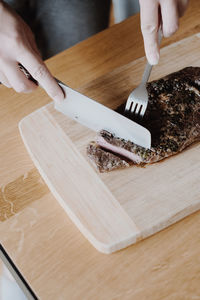 High angle view of woman preparing food on cutting board